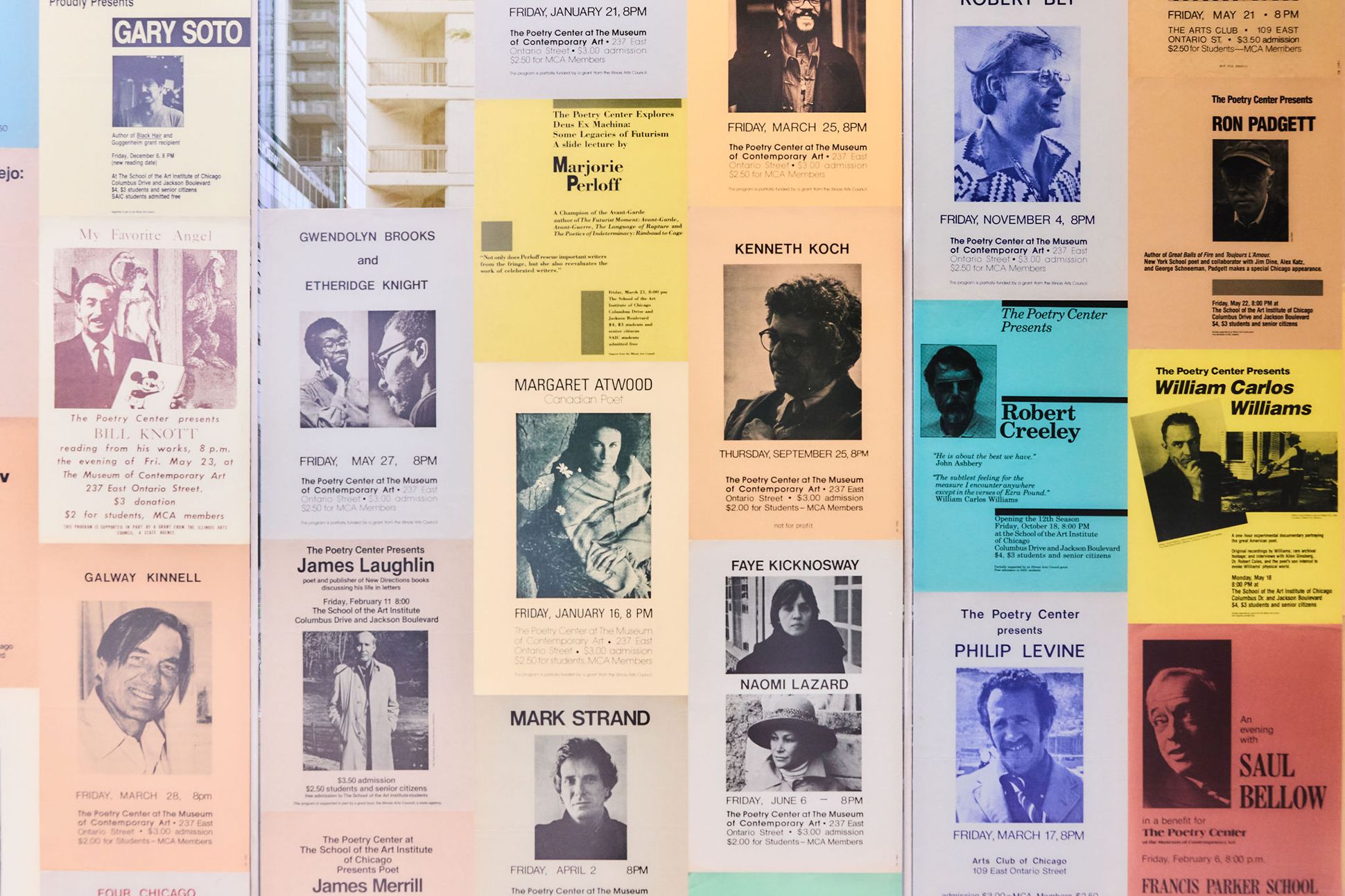 A close-up photograph of a wall of colorful poetry broadsides.