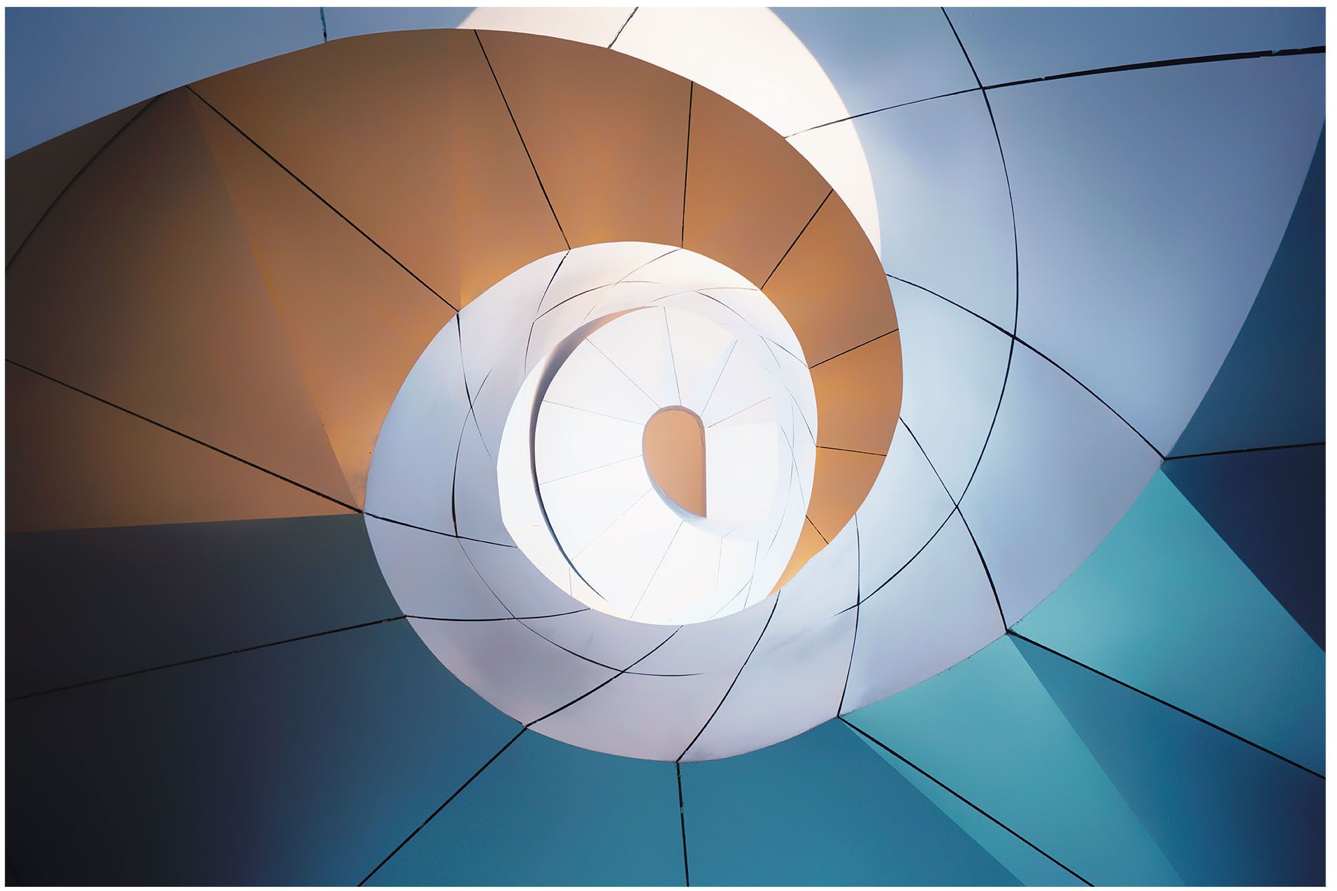 View from the bottom of a spiral staircase, shades of blue, brown and white.