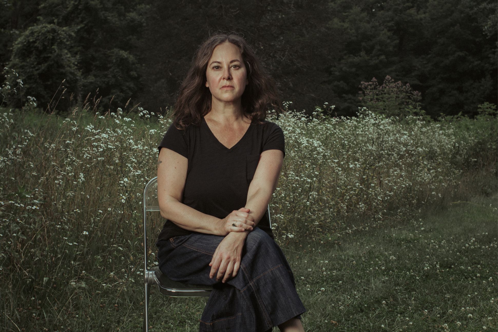 Lisa Olstein sitting in a chair outside.