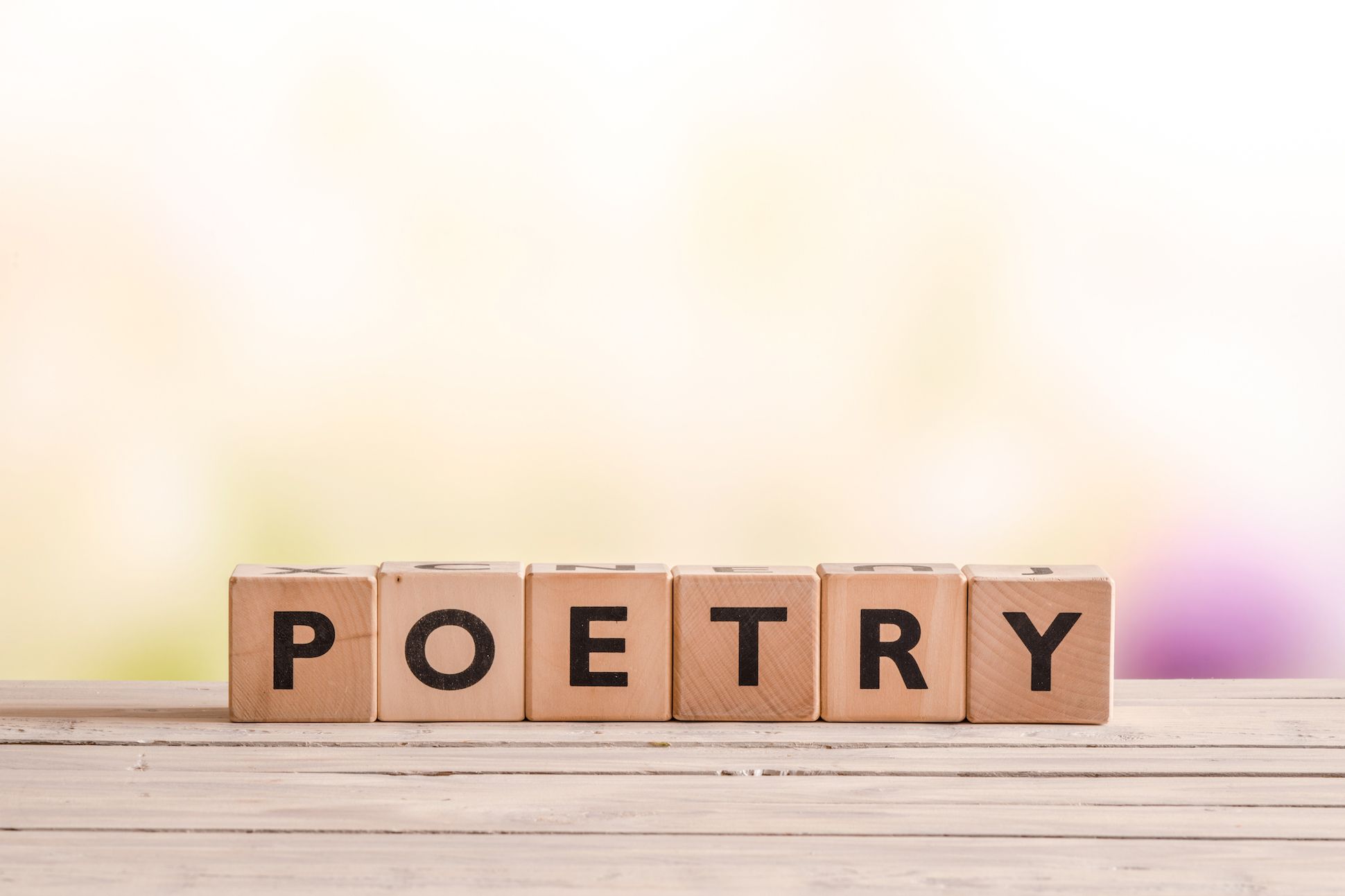 Image of wooden Scrabble tiles spelling the word "POETRY"