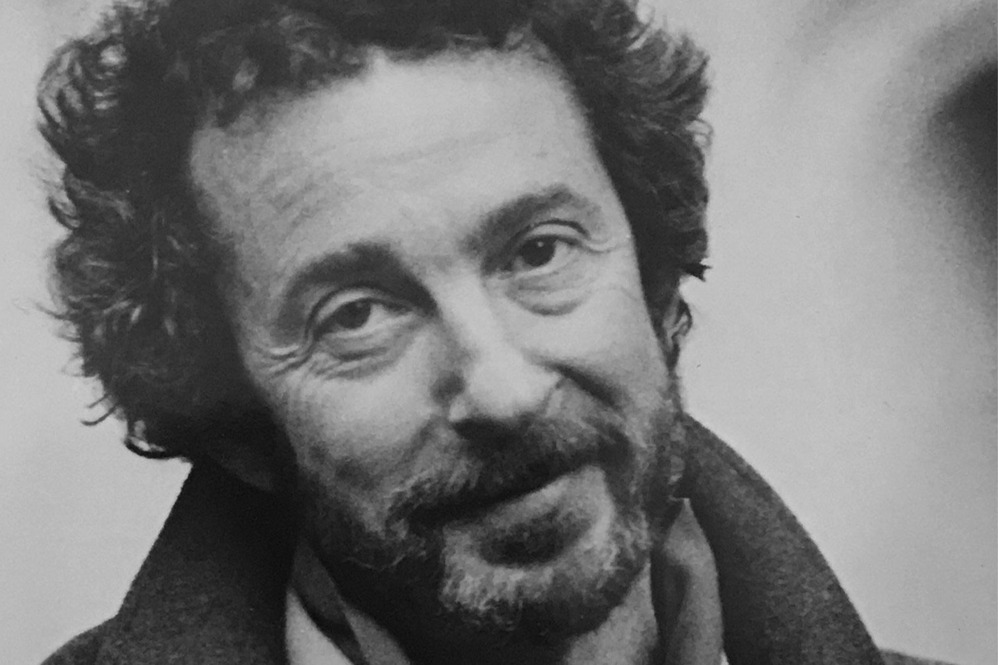 A black-and-white photograph of C.K. Williams looking into the camera.