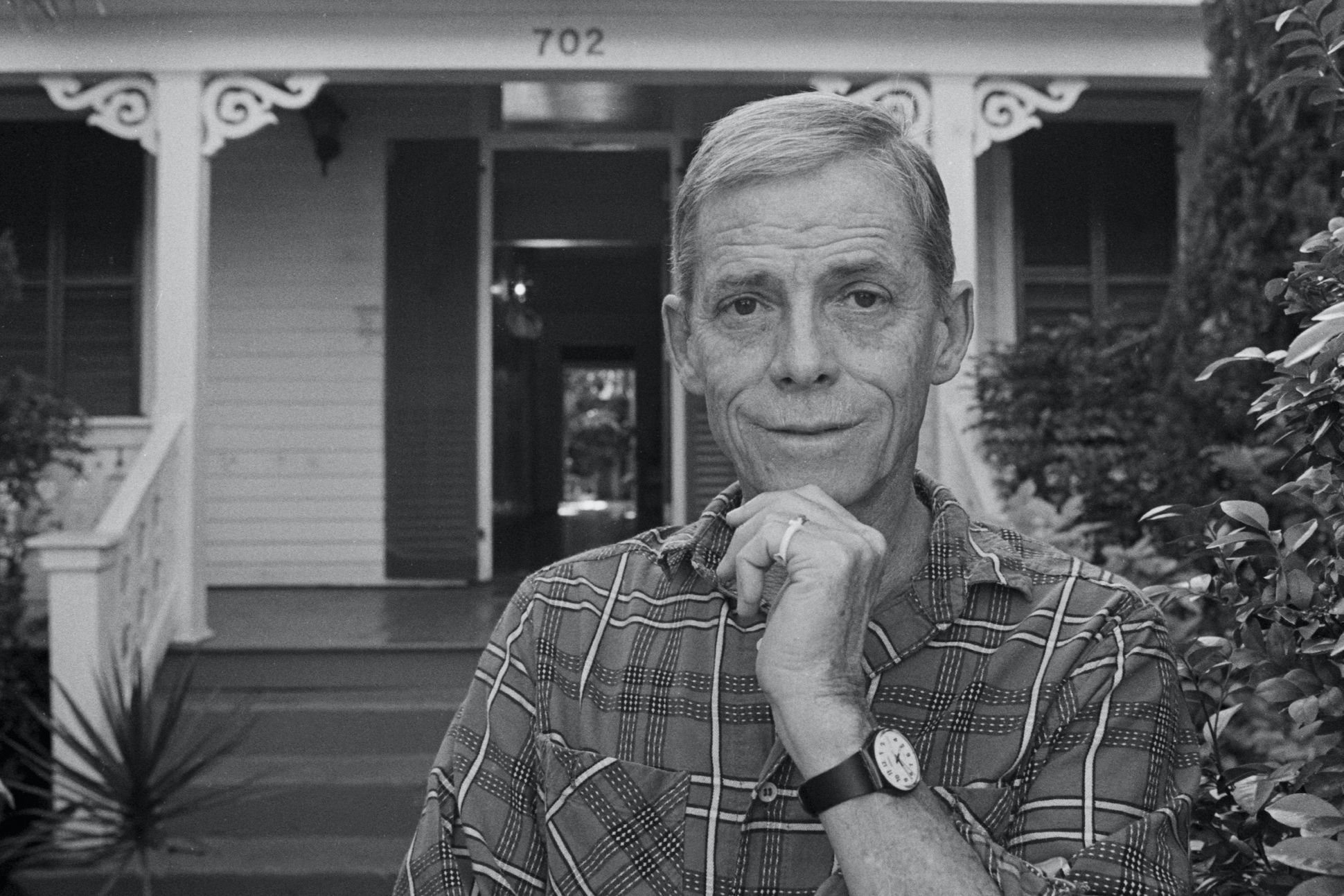 Portrait of Connecticut Poet Laureate James Merrill standing in front of his Key West home.