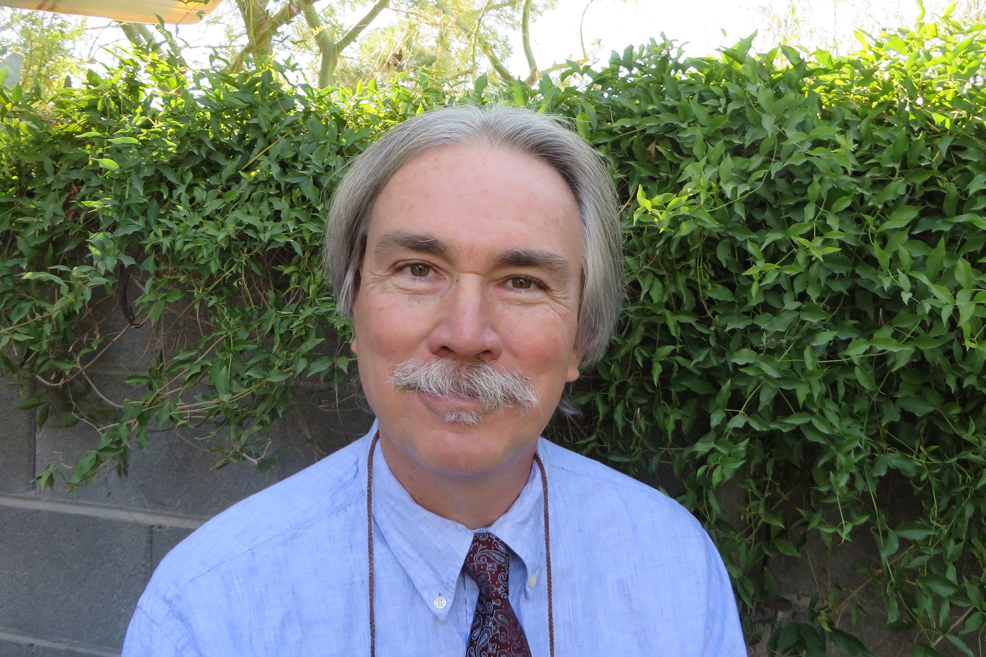 Image of  the poet Donald Revell outside.
