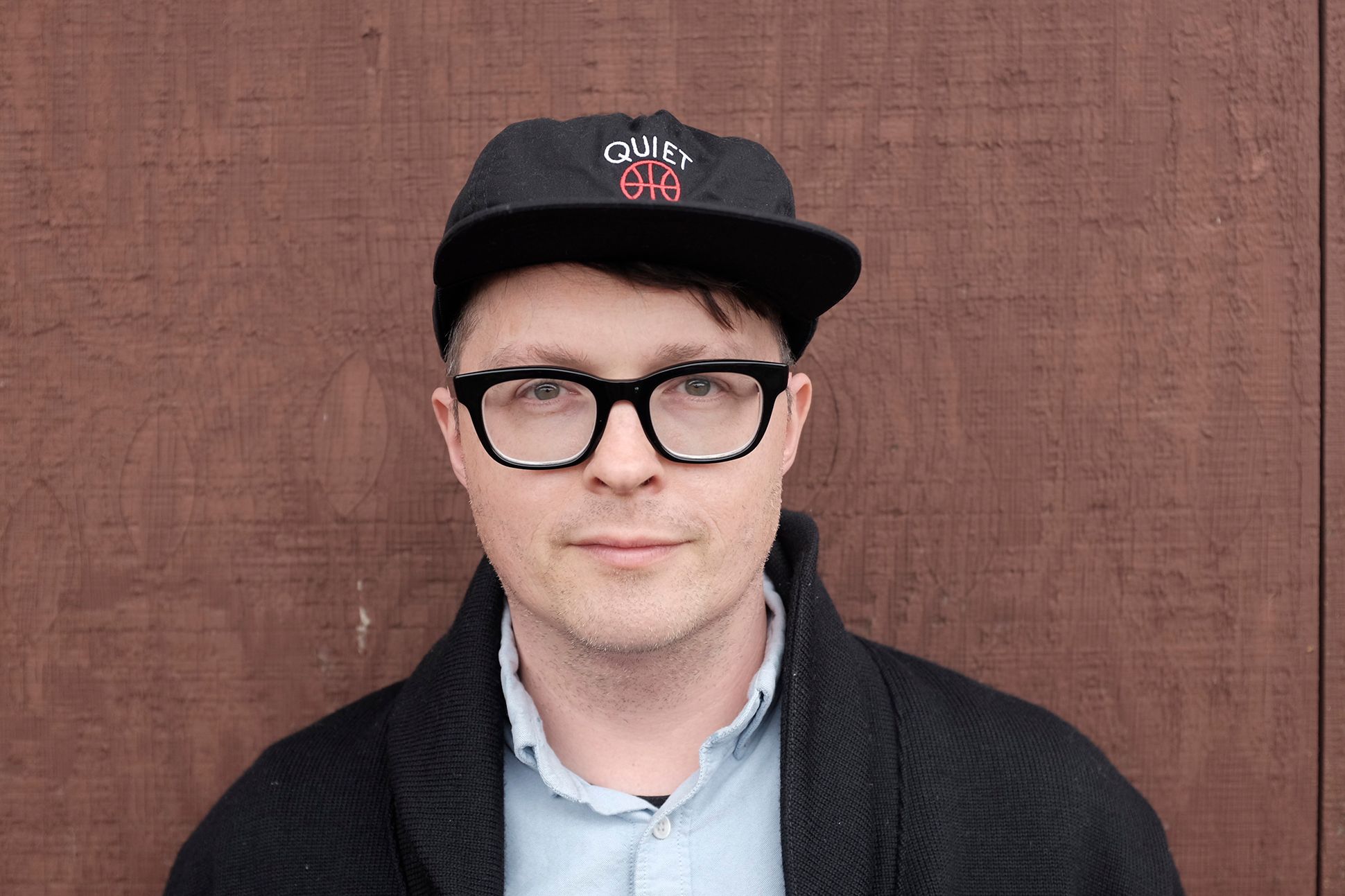 Portrait of the poet Matthew Dickman, wearing a black hat.