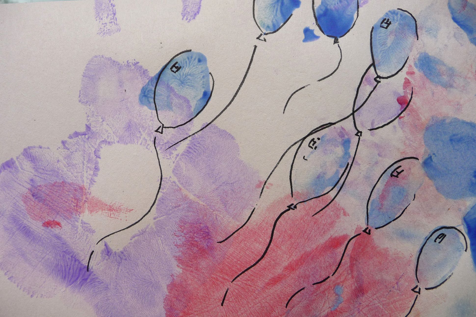 Finger painting of balloons and hand prints.