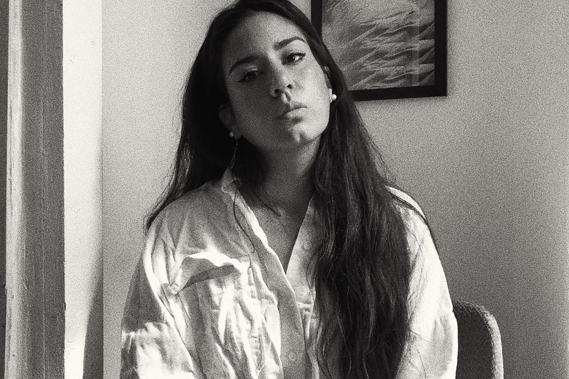 Poet Aria Aber in a black and white photo wearing a white button down.