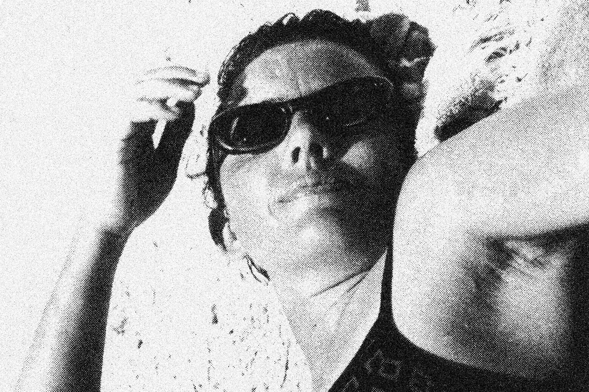 Black-and-white photo of poet Miyó Vestrini on the beach, in sunglasses.