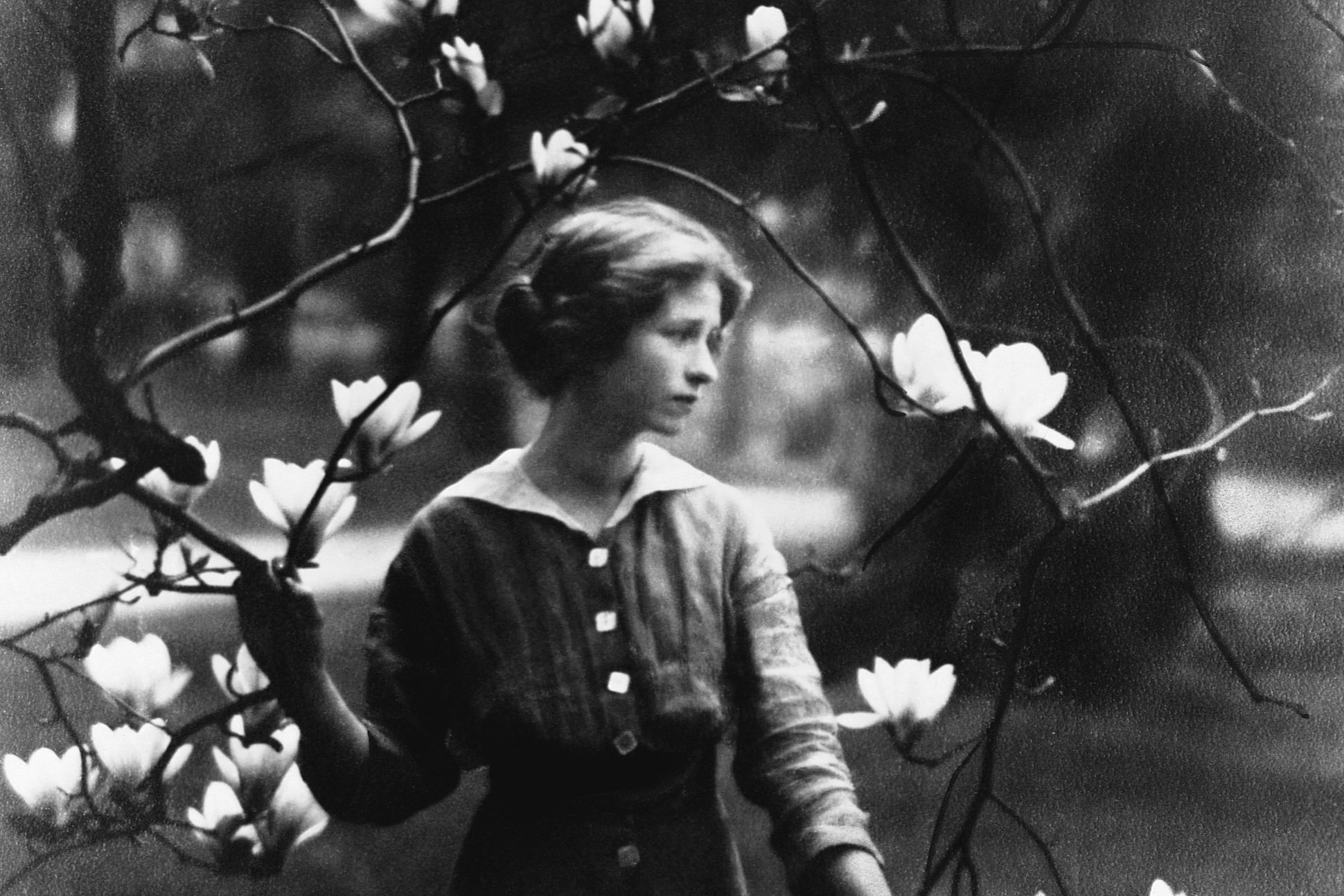 American poet Edna St. Vincent Millay (1892-1950) poses for a portrait among magnolia blossoms.