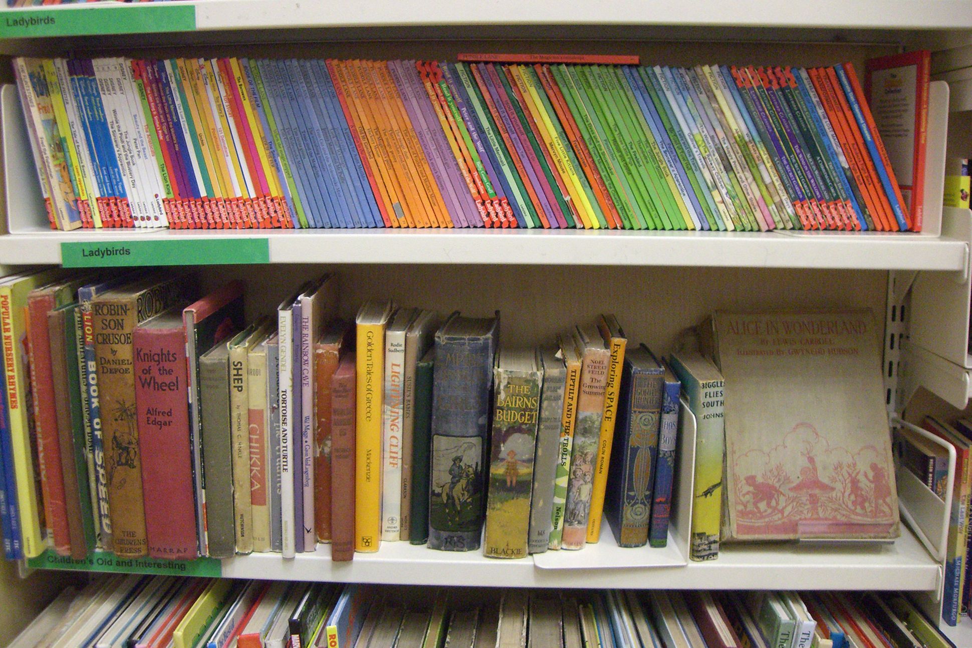 Image of second-hand children's books on a bookshelf.