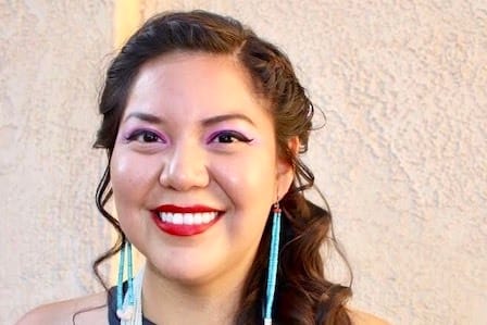 A woman with curly long hair smiling