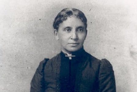 Portrait of a woman wearing a black dress with high collar