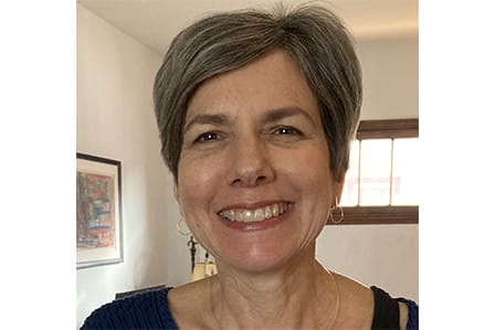 A short haired white woman smiling