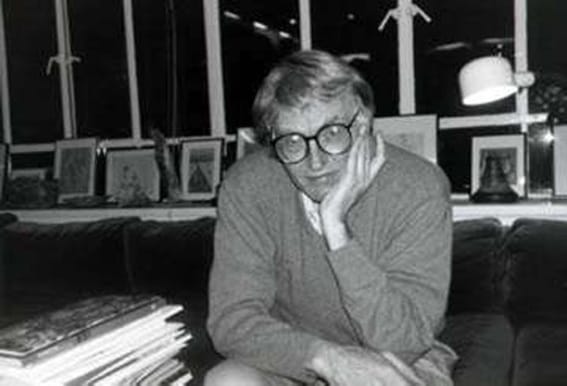 Black and white headshot of poet Bill Knott, with a hand on his face.